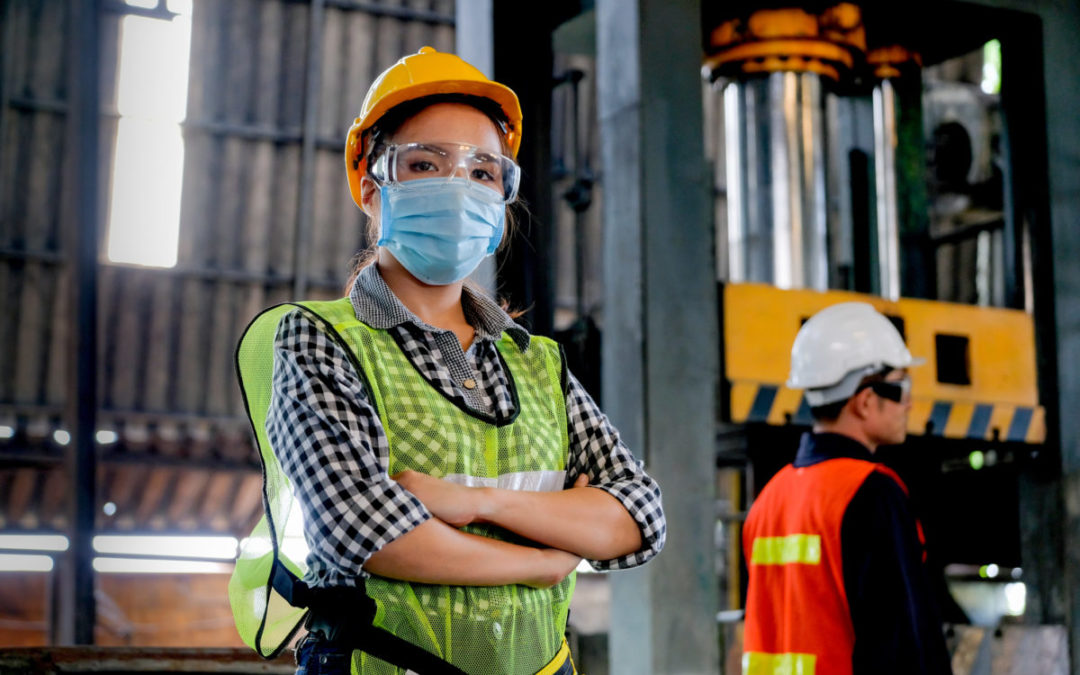 Factory woman worker or technician with hygienic mask stand with confident action with her co-worker as background HAZMAT Training
