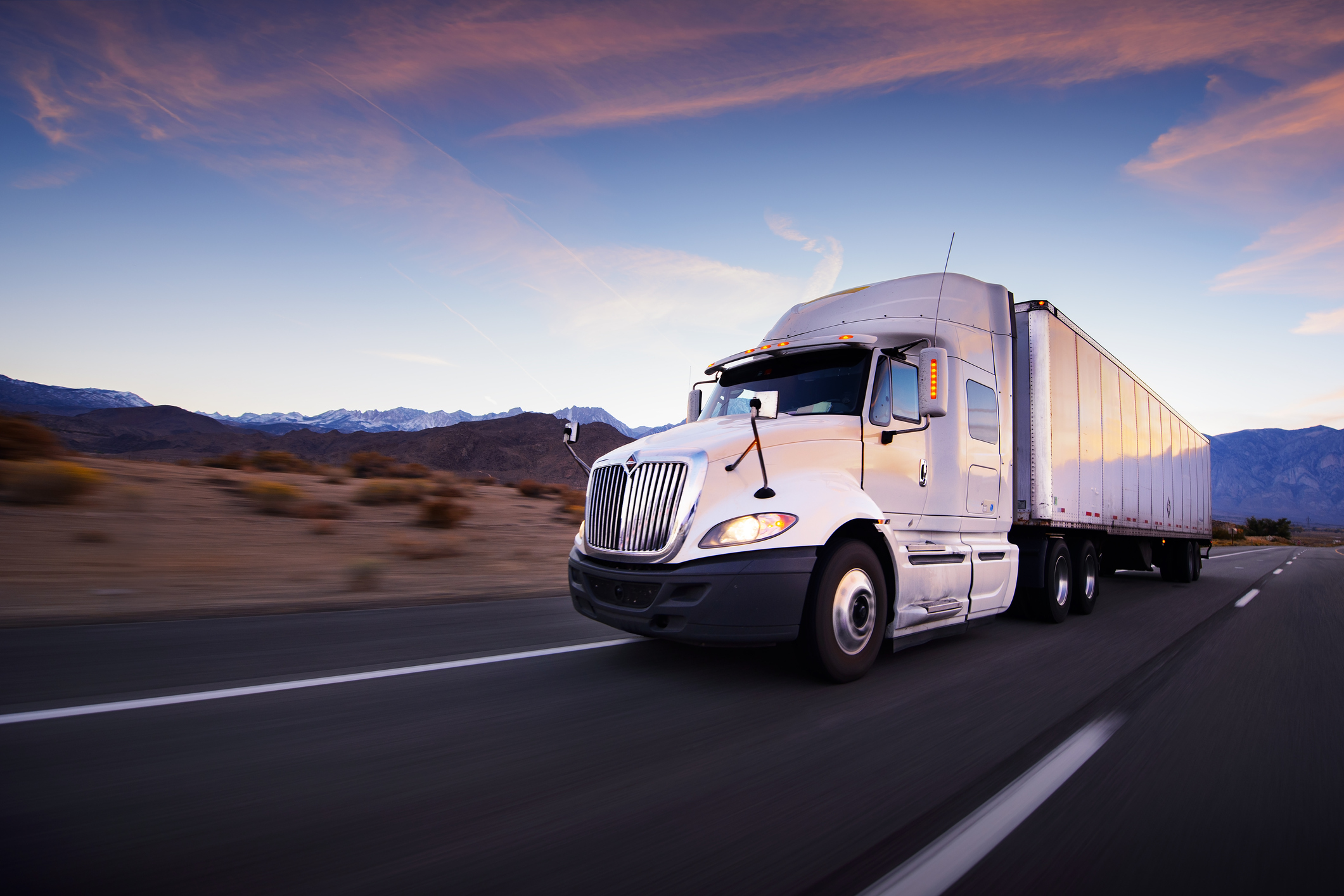 Truck and highway at sunset – transportation background Defensive Driving – Industrial Trucks